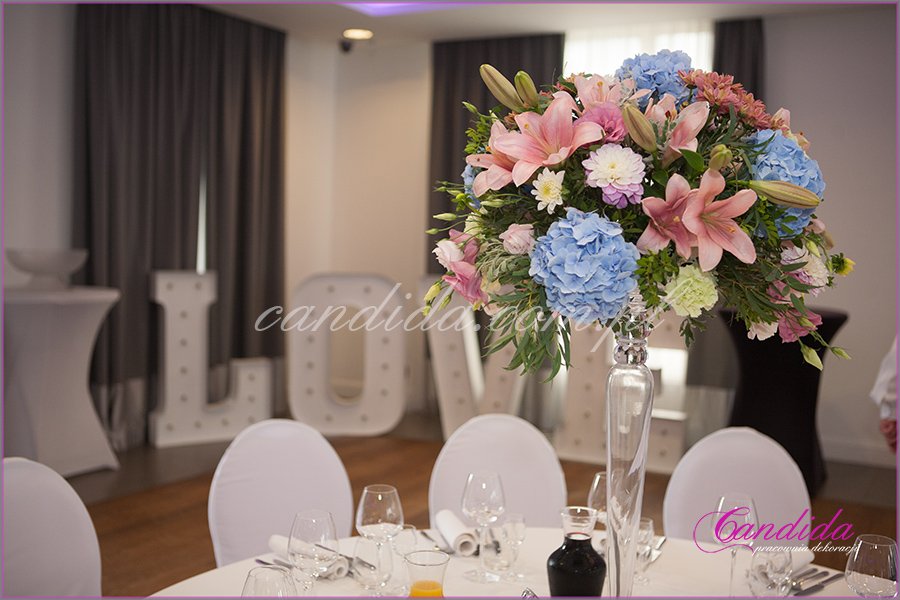 dekoracje weselne w hotelu Brant, dekoracja weselna stołu gości, kompozycja kwiatowa w wysokim naczyniu szklanym 