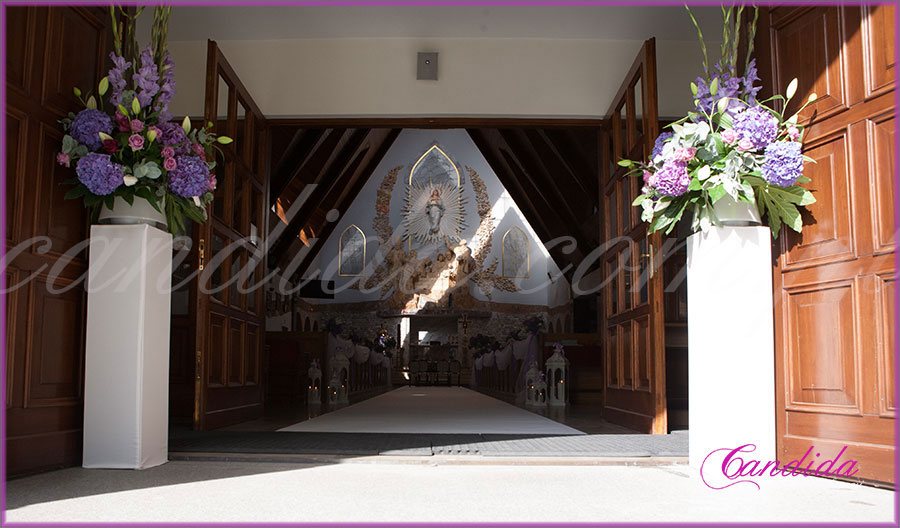 dekoracja ślubna kościoła kompozycje z hortensjami na postumentach dekoracja nawy głównej