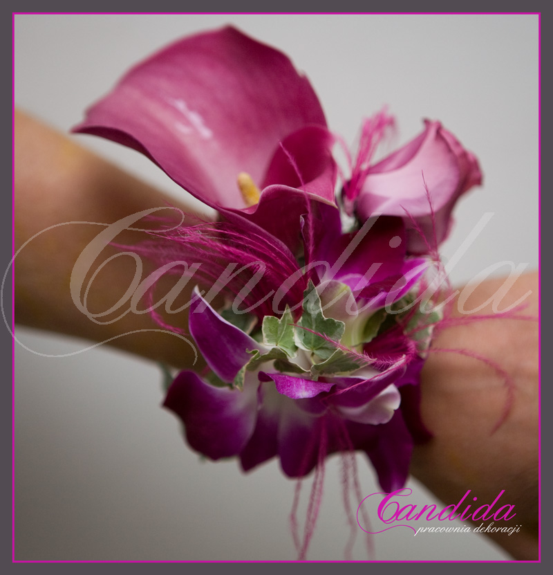 Bransoleta kwiatowa wykonana z cantedeskii, eustomy oraz storczyka dendrobium z dodatkiem hedery i piór strusia.